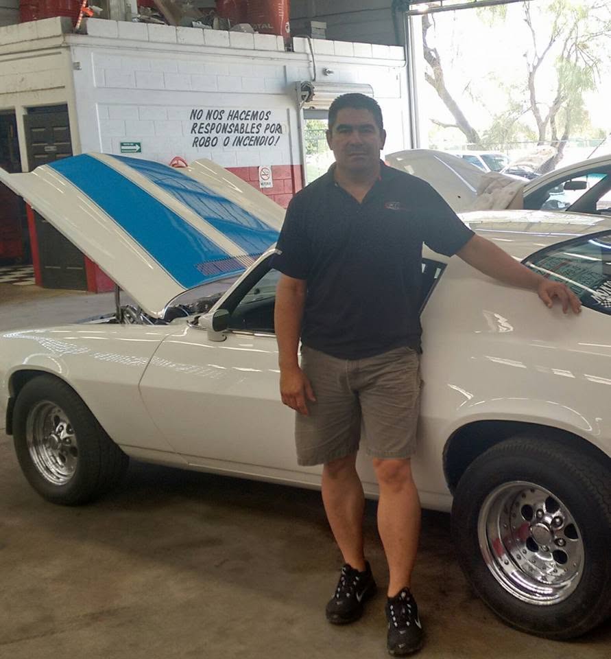Germán Gómez, dueño de GAB, junto a un carro en el taller